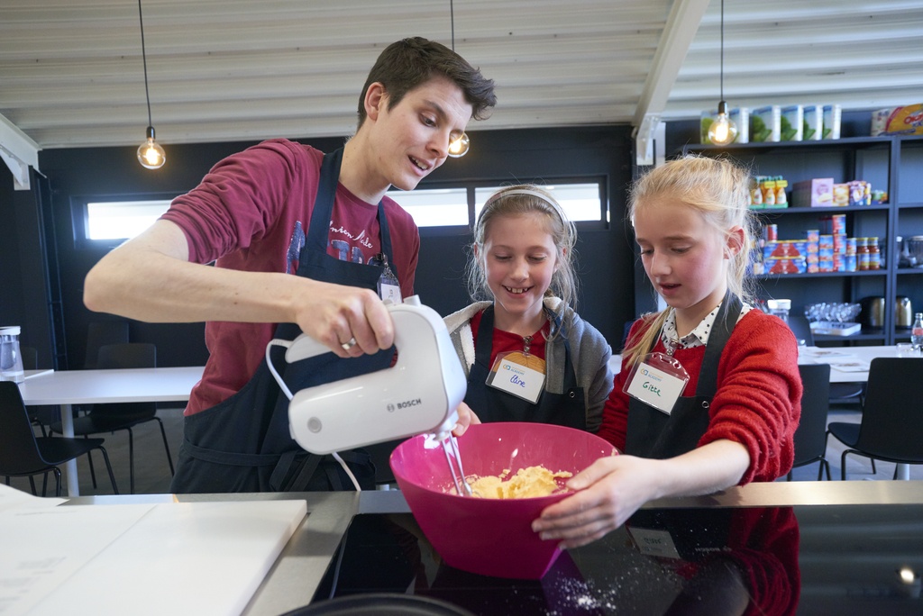 lesgeefster Tine met kinderen tijdens kookworkshop bij Colruyt Group Academy