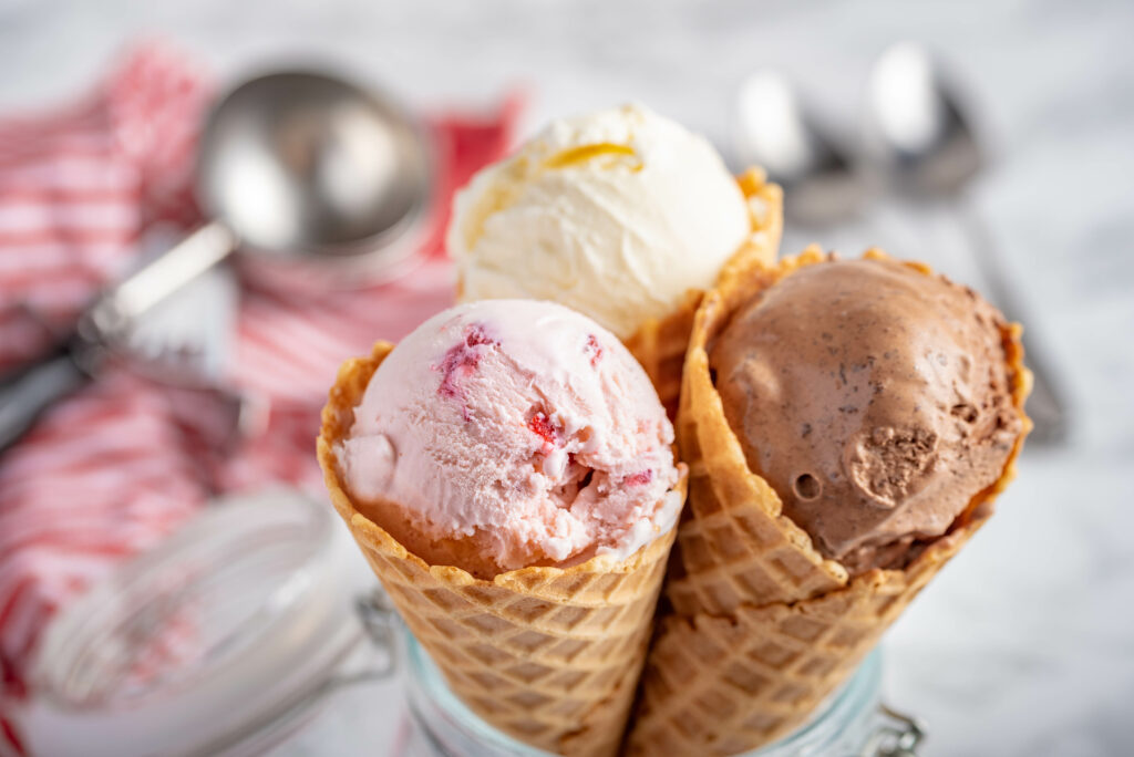 3 hoorntjes met bolletje vanille-ijs, chocolade-ijs en aardbei-ijs
